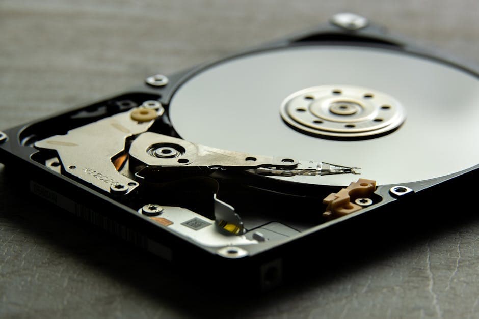 Detailed view of an open hard drive, showcasing the disk platter and actuator arm.