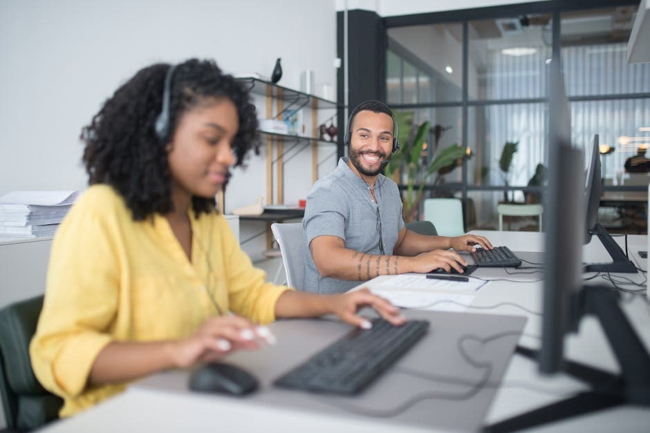 A diverse call center team working efficiently with headsets and computers, ensuring quality customer service.