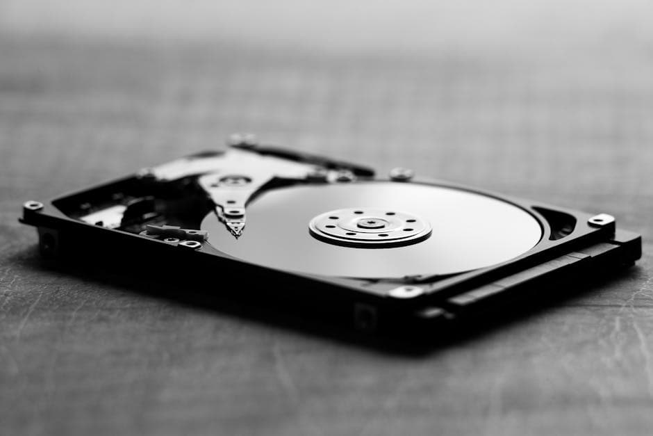 Artistic black and white shot of an open hard drive, showcasing internal components.