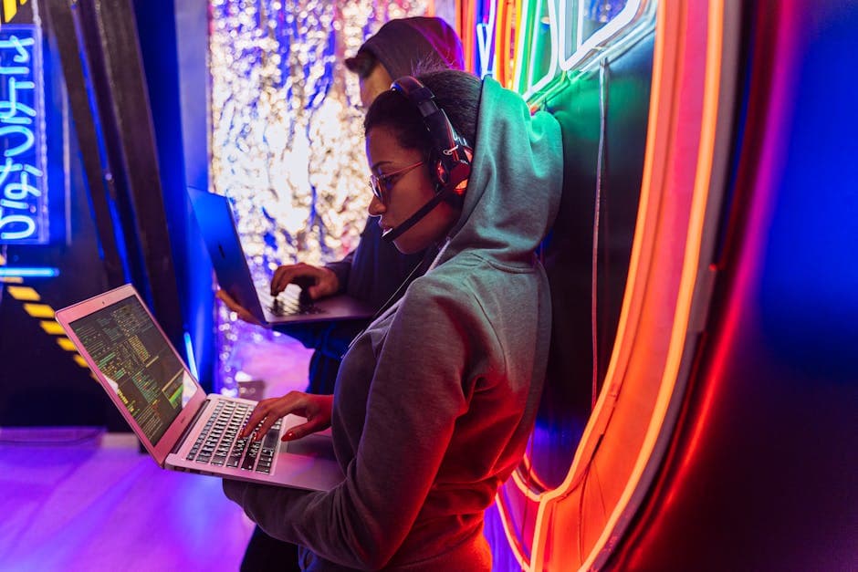 Team of cyber security experts working on laptops in a vibrant neon-lit room.