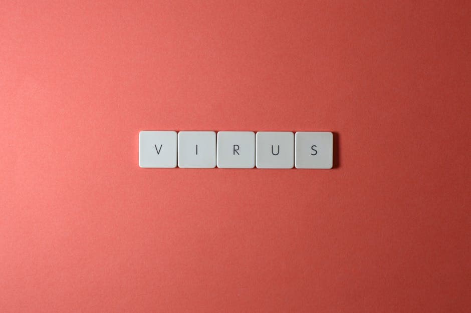 Close-up of keyboard keys spelling 'virus' against a red background, ideal for conceptual use.